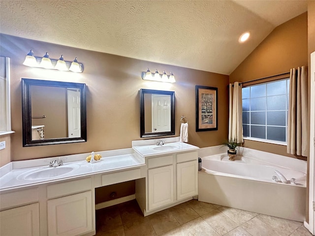 full bath featuring a garden tub, a sink, a textured ceiling, and double vanity