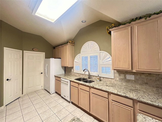 kitchen with lofted ceiling, light brown cabinetry, light tile patterned flooring, a sink, and white appliances