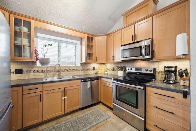 kitchen with stainless steel appliances, sink, light tile patterned floors, and backsplash