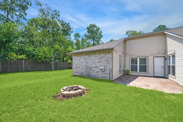 back of property with an outdoor fire pit, a patio, and a lawn