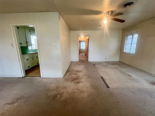 unfurnished room featuring light carpet and ceiling fan