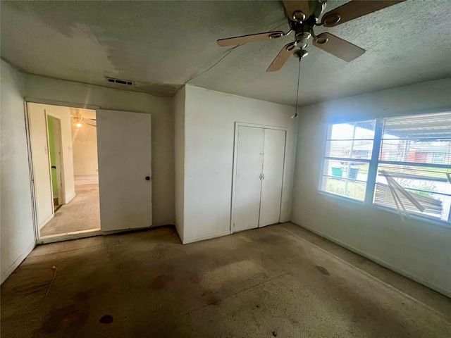 unfurnished bedroom with ceiling fan, a textured ceiling, and a closet