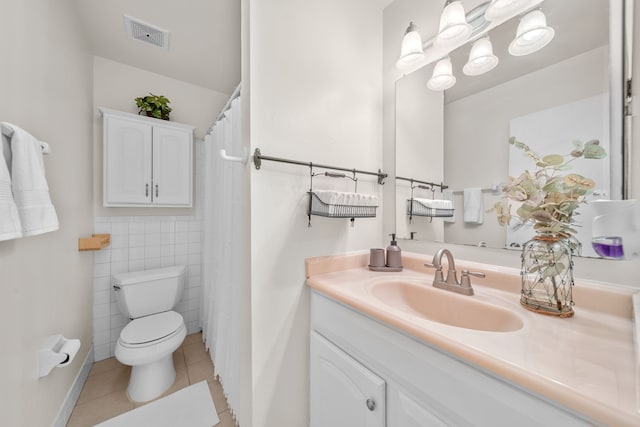 bathroom with tile patterned flooring, vanity, tile walls, and toilet