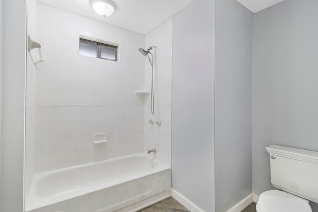 bathroom featuring tiled shower / bath and toilet