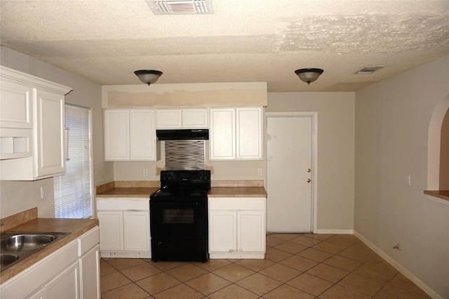 kitchen with white cabinetry, sink, light tile patterned floors, black range with electric cooktop, and a textured ceiling