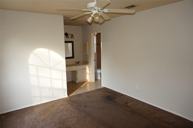 carpeted empty room featuring ceiling fan and sink