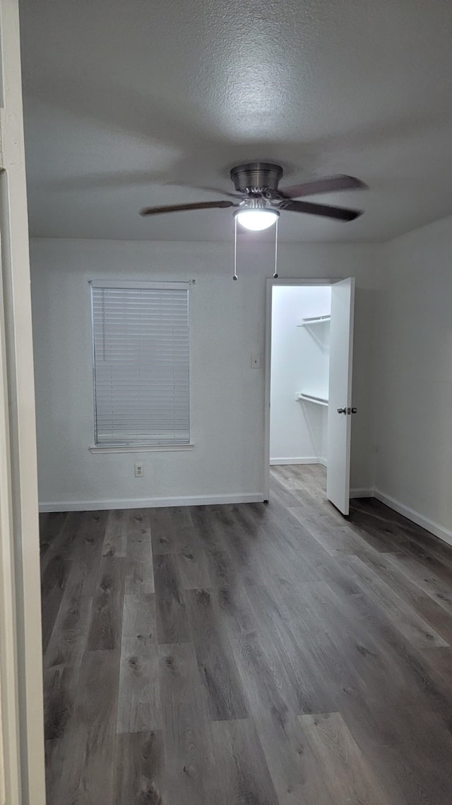 empty room with wood-type flooring, ceiling fan, and a textured ceiling