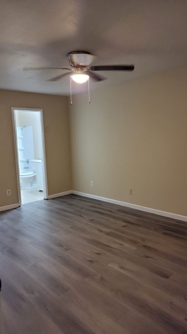 spare room featuring dark wood-type flooring and ceiling fan