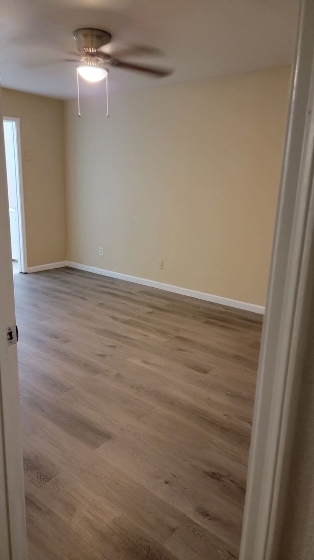 spare room with ceiling fan and light wood-type flooring