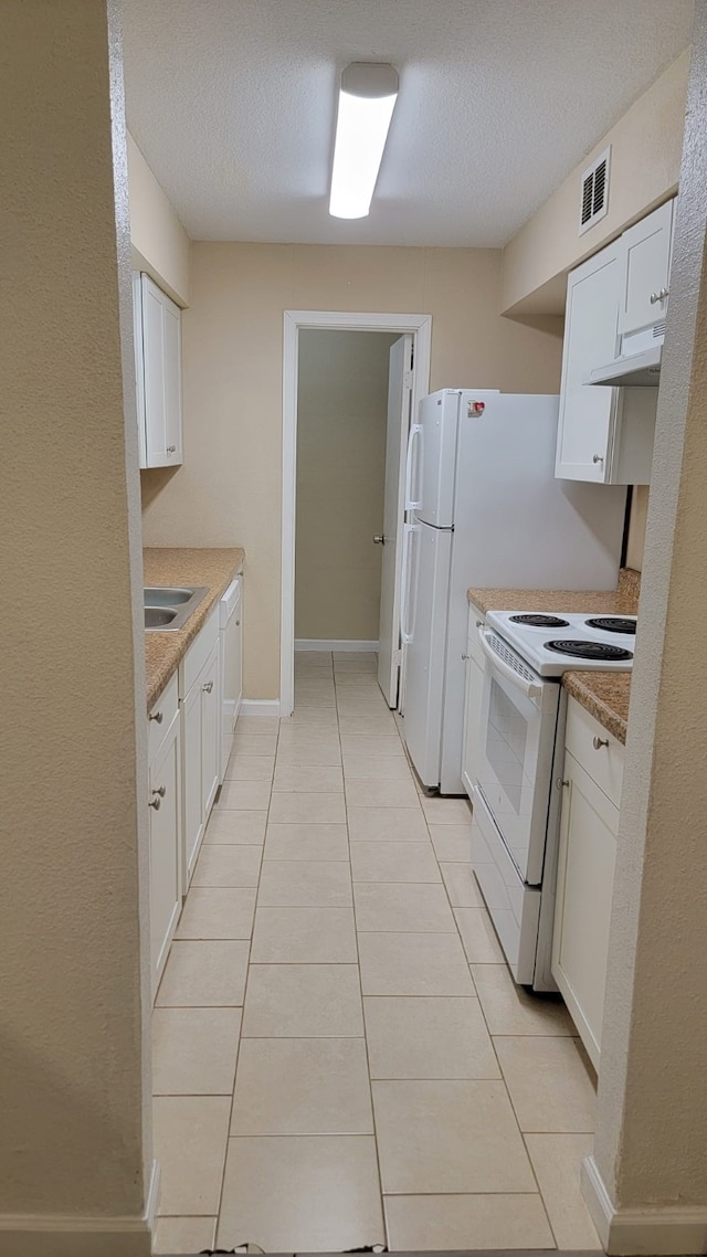 kitchen with white cabinetry, electric range, a textured ceiling, and light tile patterned flooring