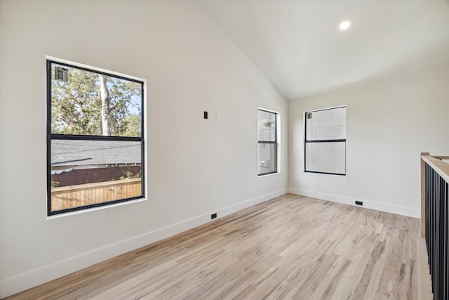 spare room featuring high vaulted ceiling and light hardwood / wood-style flooring