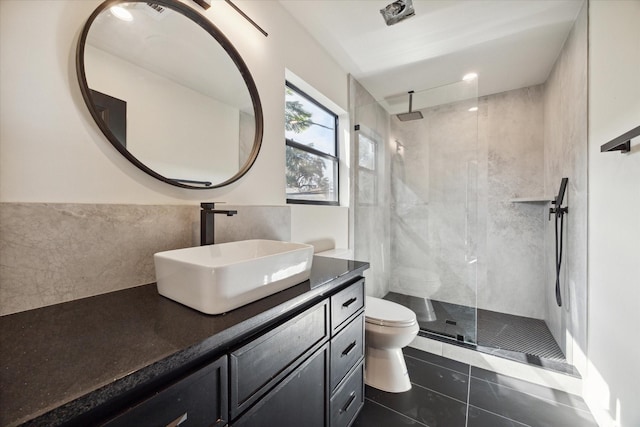 bathroom featuring vanity, tile patterned floors, toilet, and tiled shower