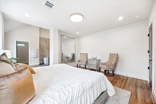 bedroom with wood-type flooring and vaulted ceiling