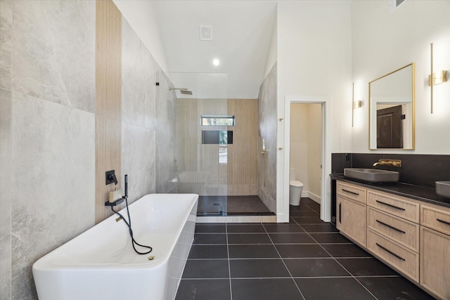 full bathroom featuring tile patterned flooring, tile walls, vanity, plus walk in shower, and toilet