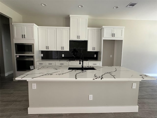 1037 Rd 6609, Dayton, TX 77535 - kitchen with oven, stainless steel microwave, a kitchen island with sink, white cabinets, and recessed lighting