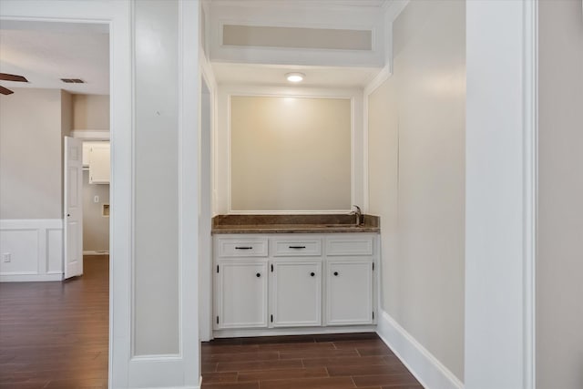 bar with baseboards, visible vents, ceiling fan, dark wood-style flooring, and a sink