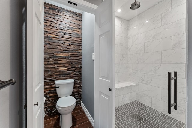 bathroom with toilet, a stall shower, baseboards, and wood finish floors