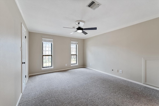 spare room with a ceiling fan, baseboards, visible vents, and carpet flooring