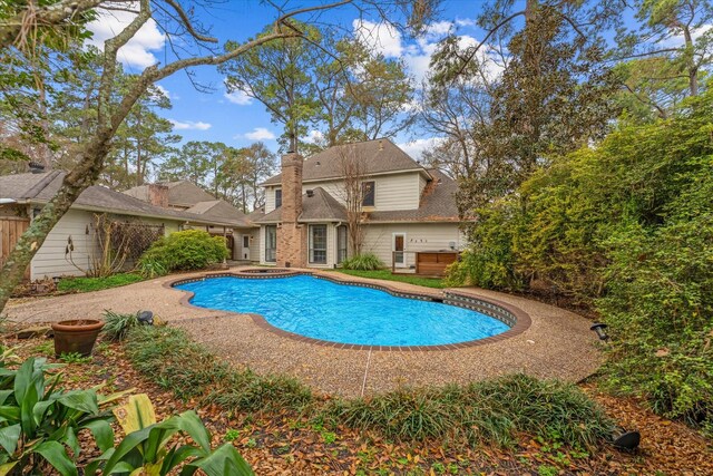 view of swimming pool featuring an in ground hot tub