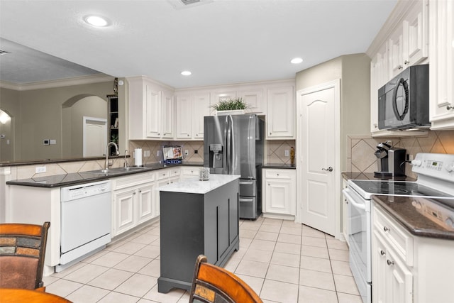 kitchen featuring white appliances, sink, a kitchen island, and white cabinets