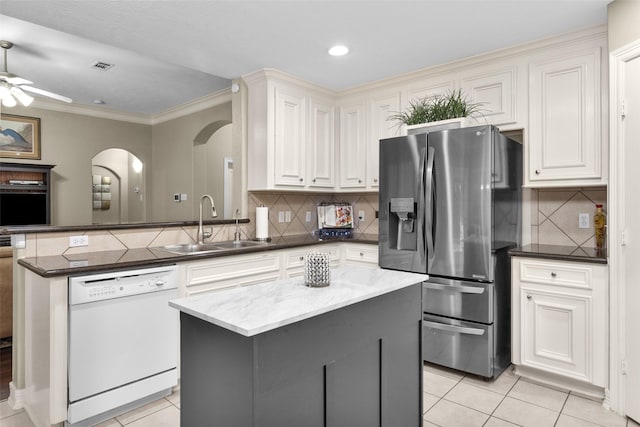 kitchen featuring sink, dark stone countertops, a center island, stainless steel refrigerator with ice dispenser, and white dishwasher