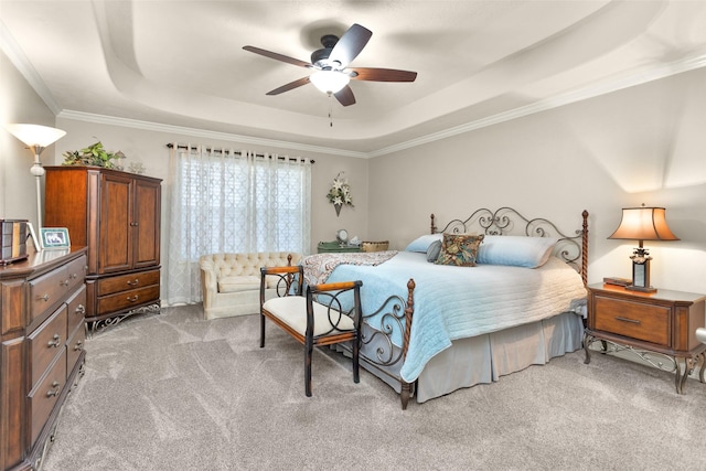 bedroom with ceiling fan, ornamental molding, a tray ceiling, and light carpet