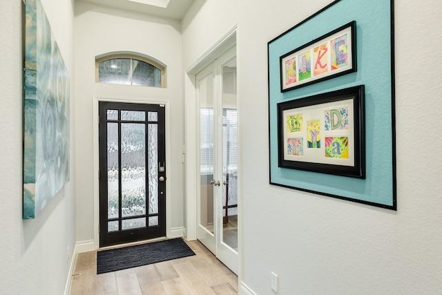 foyer entrance with a wealth of natural light and light hardwood / wood-style floors