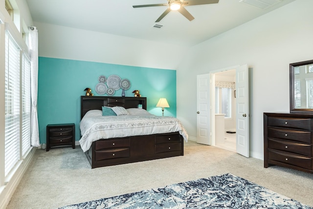 bedroom with lofted ceiling, ceiling fan, multiple windows, and light carpet