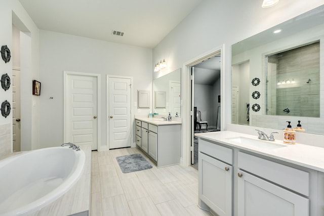 bathroom with vanity and shower with separate bathtub