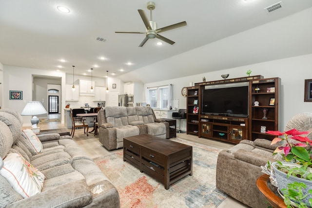 living room with ceiling fan, lofted ceiling, and light wood-type flooring