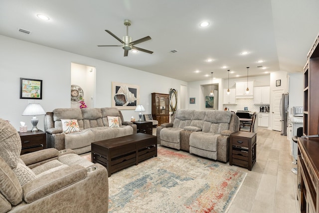 living room with ceiling fan and light hardwood / wood-style flooring