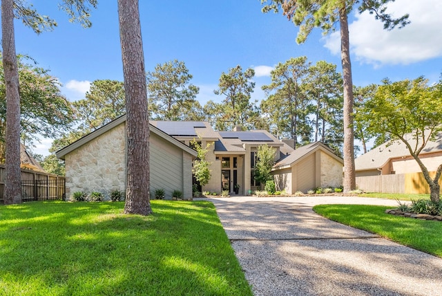 view of front of house featuring a front yard and solar panels