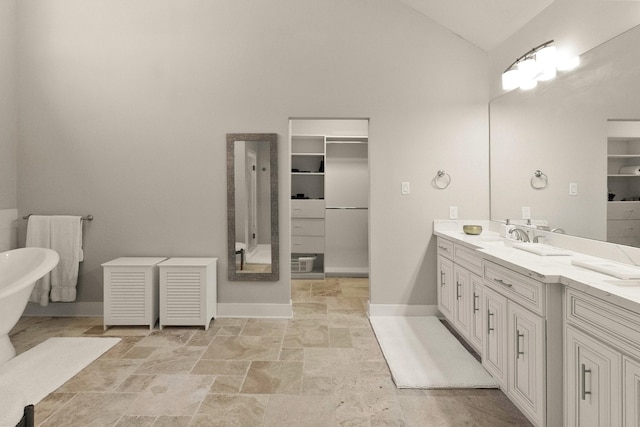 bathroom with lofted ceiling, vanity, and a bathing tub