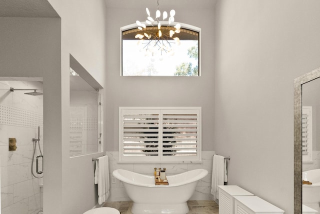 bathroom with plus walk in shower, tile walls, and a chandelier