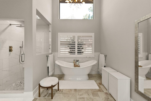 bathroom with tile walls, a chandelier, plus walk in shower, and a healthy amount of sunlight