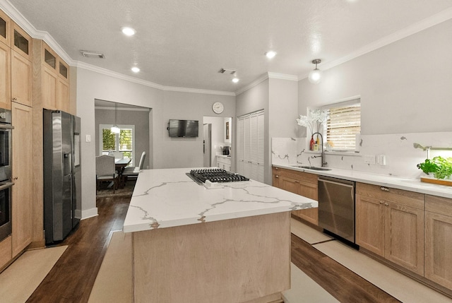 kitchen featuring sink, appliances with stainless steel finishes, light stone counters, a kitchen island, and dark hardwood / wood-style flooring