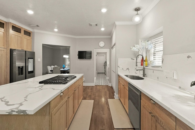 kitchen with sink, crown molding, dark wood-type flooring, stainless steel appliances, and decorative light fixtures