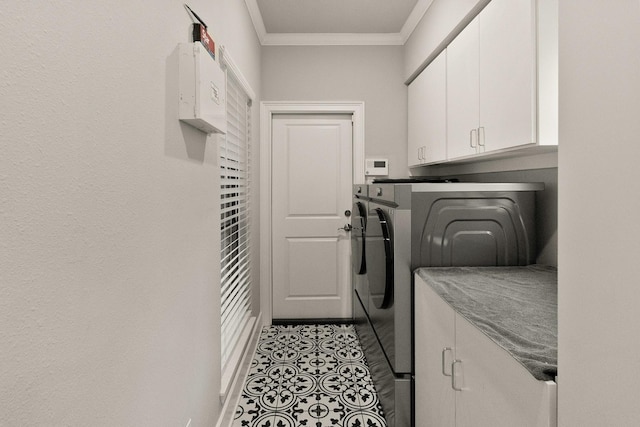 laundry room with cabinets, ornamental molding, washer and clothes dryer, and light tile patterned floors