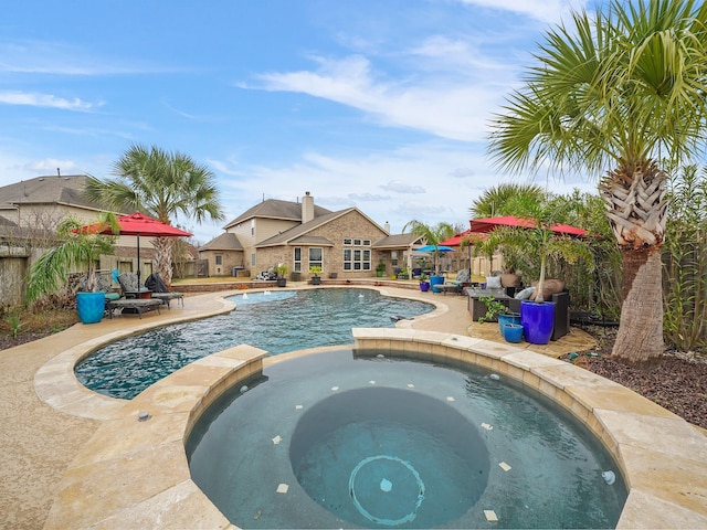 view of swimming pool featuring an in ground hot tub, pool water feature, and a patio area