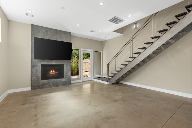 unfurnished living room with a large fireplace and concrete floors