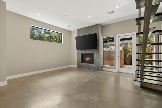 unfurnished living room with a fireplace and concrete flooring