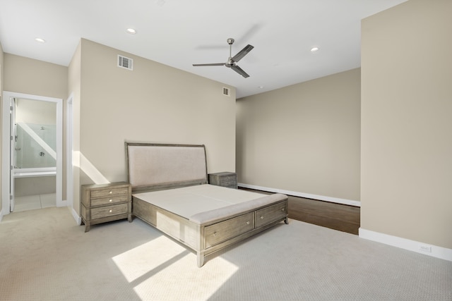 unfurnished bedroom featuring ensuite bath, light colored carpet, and ceiling fan