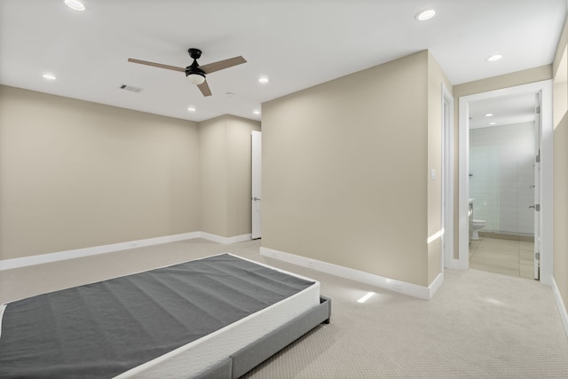 unfurnished bedroom with light carpet, ceiling fan, and ensuite bathroom