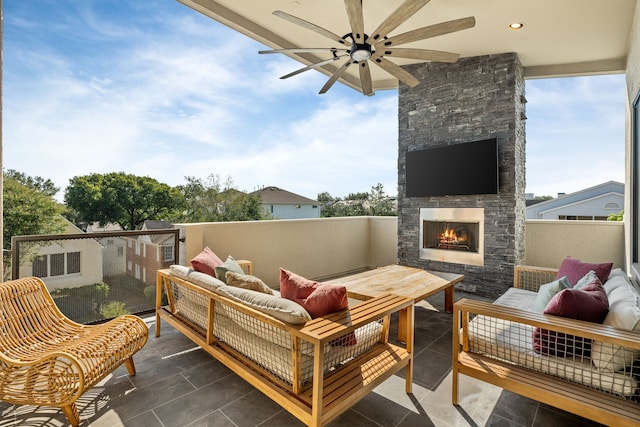 view of patio with an outdoor living space with a fireplace and ceiling fan