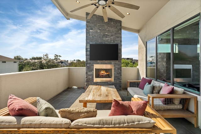 balcony featuring ceiling fan and an outdoor stone fireplace