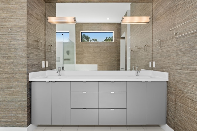 bathroom featuring vanity, tile patterned flooring, tile walls, and walk in shower