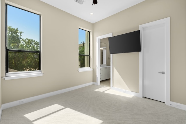 unfurnished bedroom with connected bathroom and light colored carpet