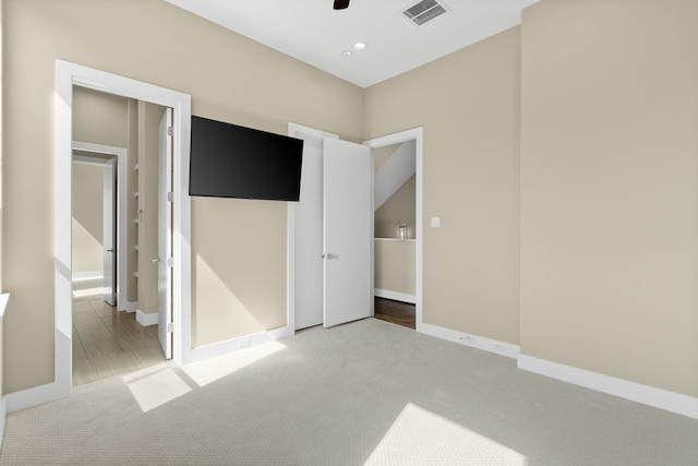 unfurnished bedroom featuring ceiling fan and light carpet