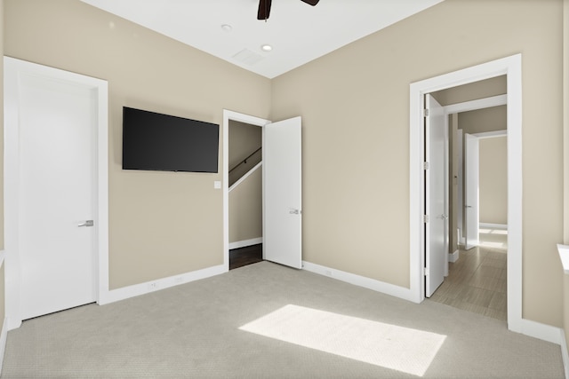 unfurnished bedroom with ceiling fan and light colored carpet