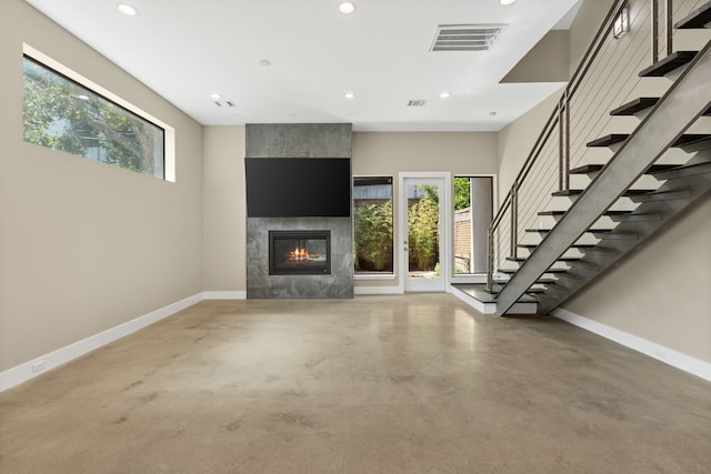 unfurnished living room featuring a premium fireplace and concrete floors